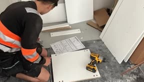 Kitchen installer checking installation specificatoins on site