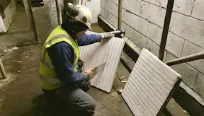 Passive fire stopper cutting fire batt according to site specifications in the workplace