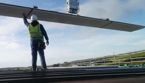 NVQ Level 2 roof cladder lowering the sheeting material for cladding