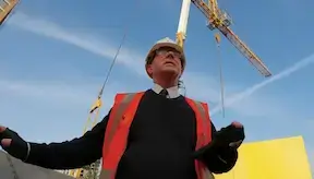 Construction senior manager standing under the crane on a construction site